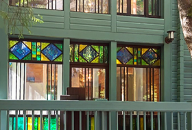 Фасад коттеджа с витражной группой. Окна с горбыльками (фальш-переплетами).